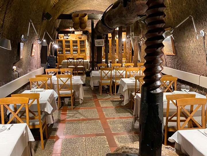 Sala con prensa de vino histórica y mesas vestidas